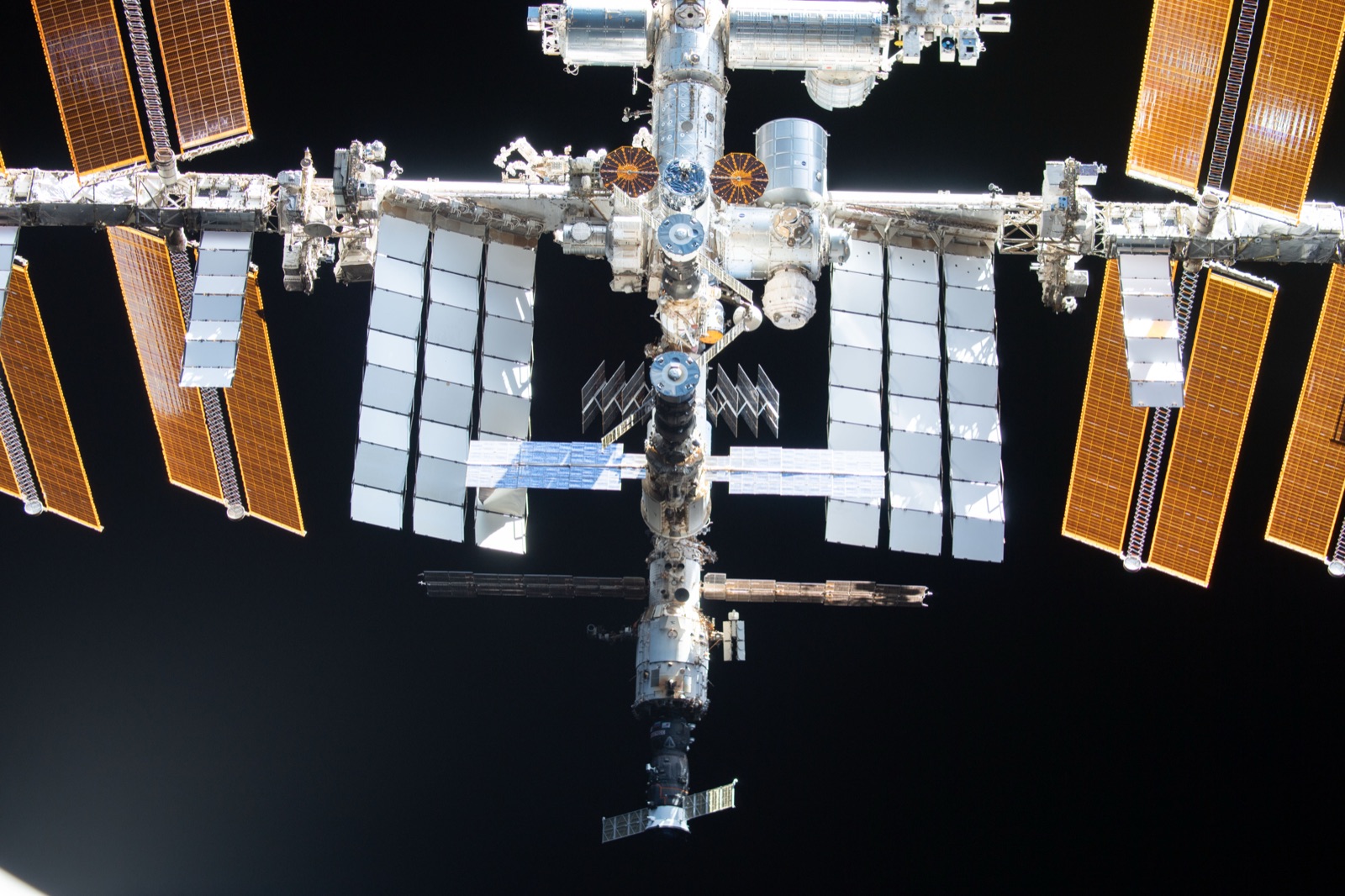 A second frame from the Crew-2 flyaround, showing the International Space Station solar arrays and modules with the Earth below.